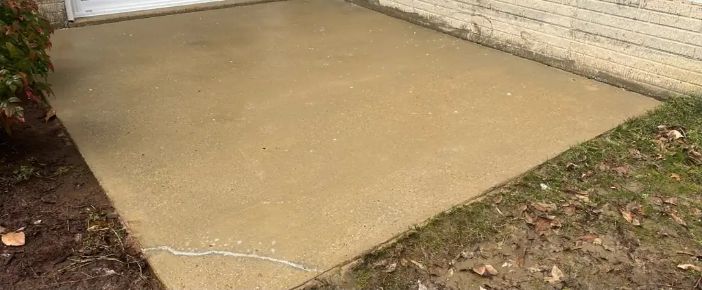 Concrete patio slab beside a sliding door, clean and even in tone after washing