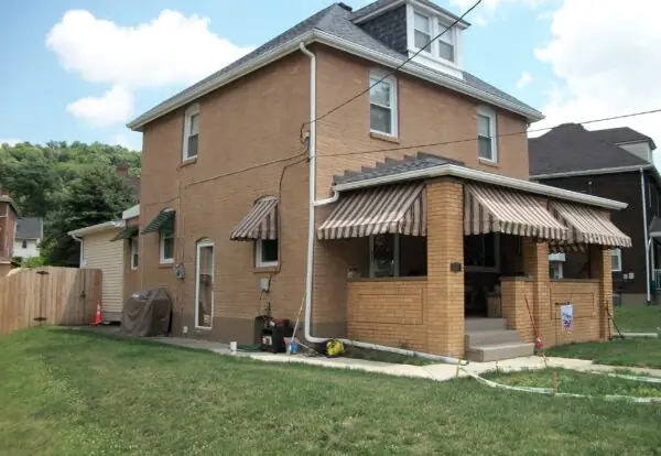 Brick house with striped awnings after washing
